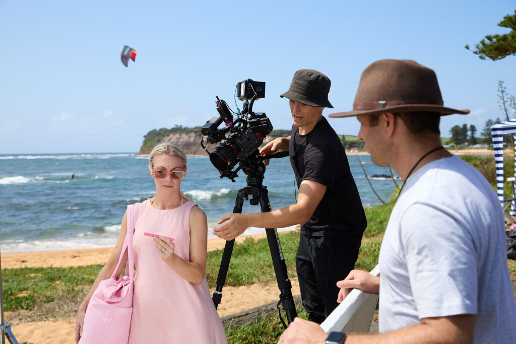 Videographer filming on a beach in Sydney
